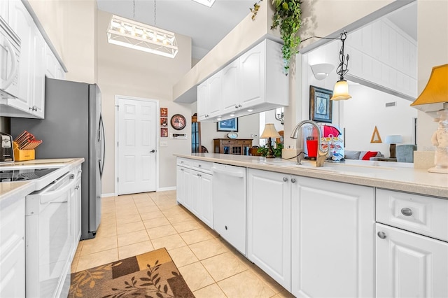 kitchen featuring sink, white cabinets, pendant lighting, white appliances, and light tile patterned floors