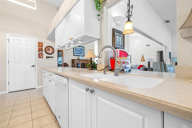 kitchen with pendant lighting, dishwasher, sink, light tile patterned floors, and white cabinetry