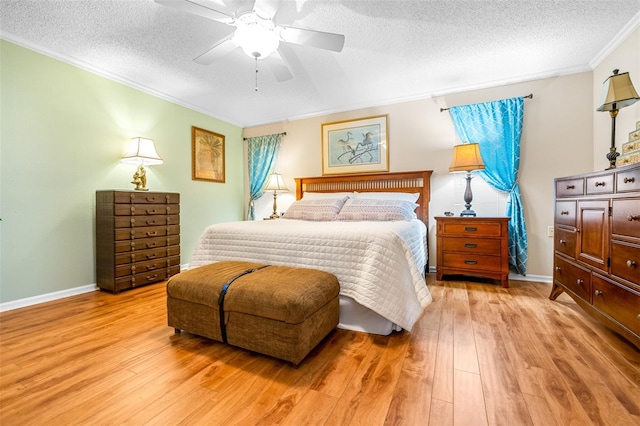 bedroom with ceiling fan, light hardwood / wood-style floors, and a textured ceiling