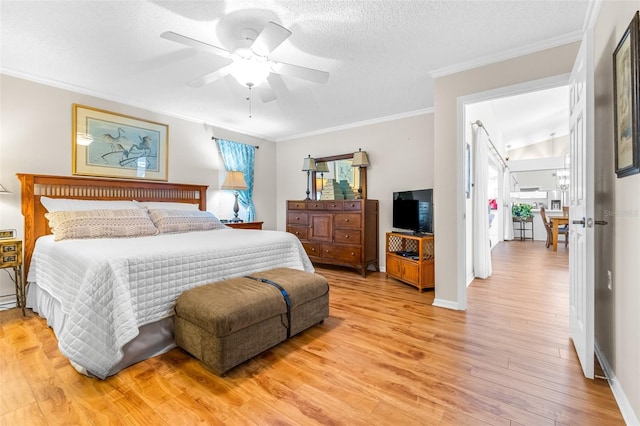 bedroom featuring ceiling fan, crown molding, a textured ceiling, and light wood-type flooring