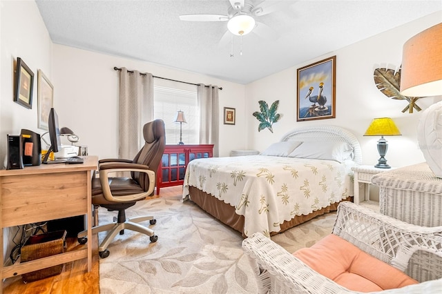 bedroom featuring light carpet, a textured ceiling, and ceiling fan