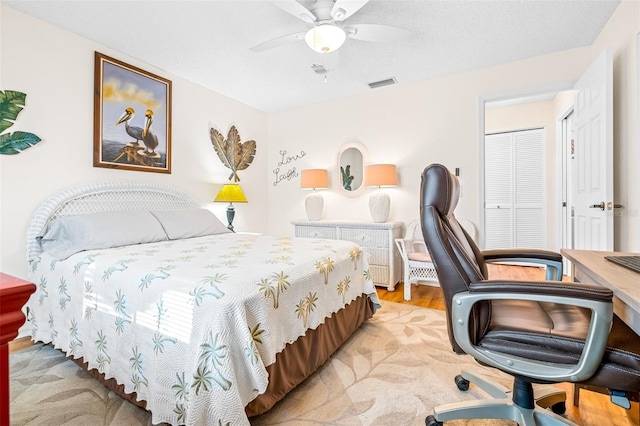 bedroom with light wood-type flooring, a closet, and ceiling fan