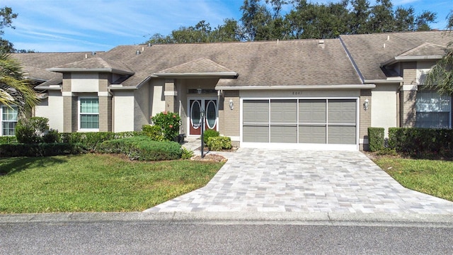 single story home featuring a front yard and a garage