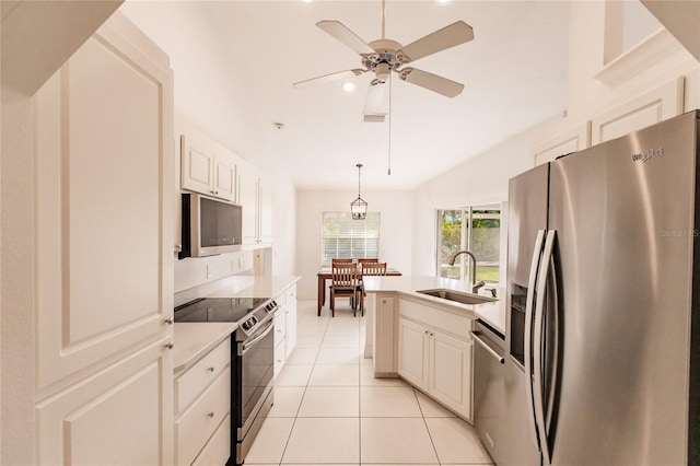 kitchen with white cabinets, sink, hanging light fixtures, light tile patterned flooring, and stainless steel appliances