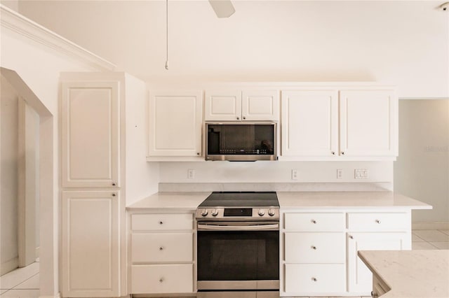 kitchen with white cabinets, ceiling fan, light tile patterned floors, and stainless steel appliances