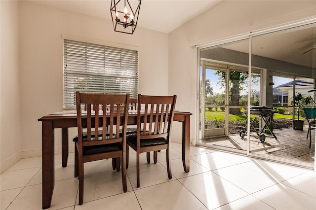 dining space with vaulted ceiling, light tile patterned floors, and a chandelier