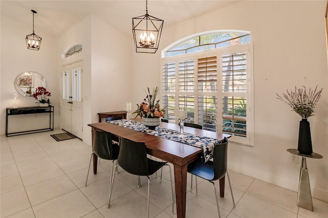 dining room featuring lofted ceiling, light tile patterned floors, and a chandelier