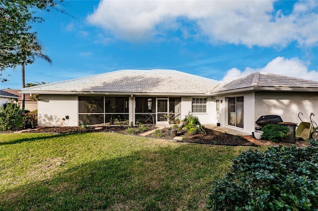 rear view of property featuring a lawn and a sunroom