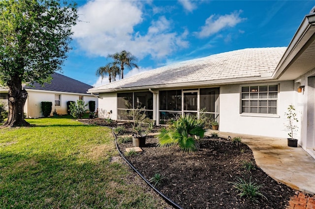 back of property featuring a sunroom and a yard