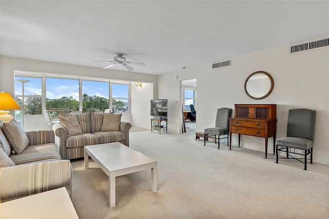 carpeted living room with ceiling fan