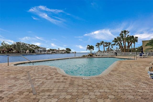 view of pool with a patio area and a water view