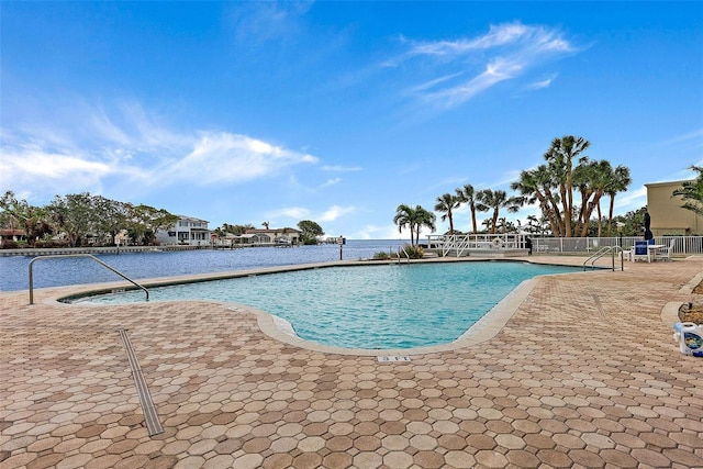 view of pool featuring a patio and a water view