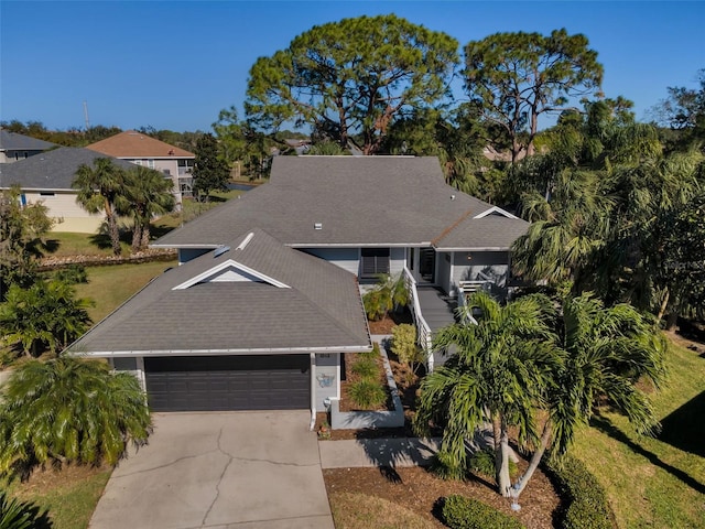 1012 Osprey Ct, Tarpon Springs, FL 34689 - view of front of house featuring driveway, a shingled roof, an attached garage, and a front yard