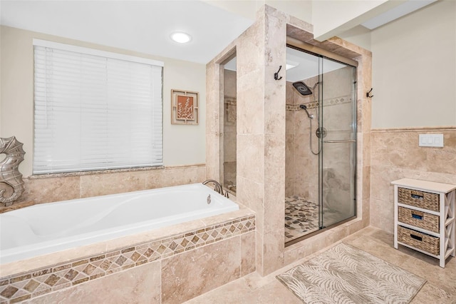 1012 Osprey Ct, Tarpon Springs, FL 34689 - full bath with a garden tub, a stall shower, tile walls, and a wainscoted wall