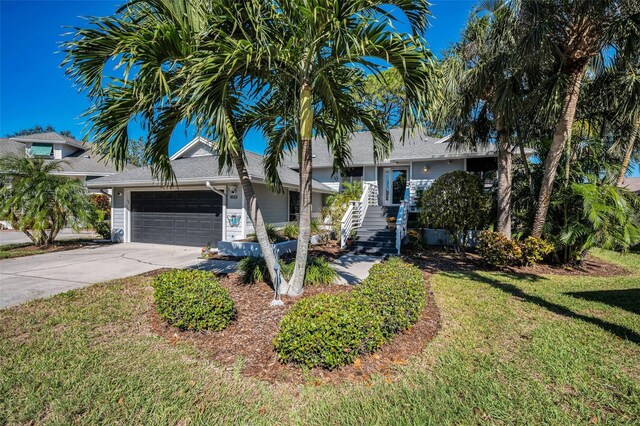 1012 Osprey Ct, Tarpon Springs, FL 34689 - obstructed view of property with an attached garage, a front yard, and concrete driveway