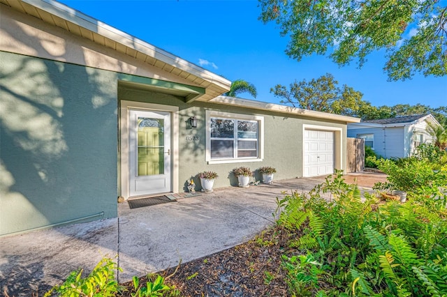 doorway to property with a patio and a garage