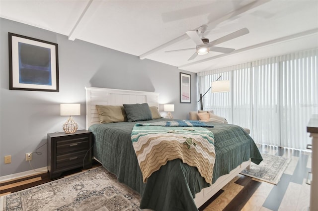 bedroom with ceiling fan, beamed ceiling, and wood-type flooring