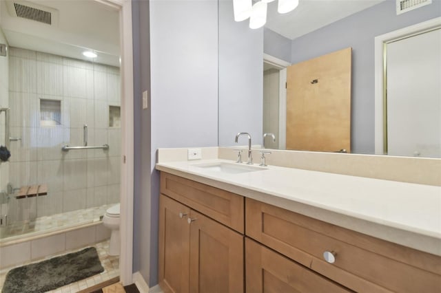 bathroom with tile patterned floors, vanity, toilet, and a shower with door