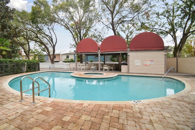 view of swimming pool featuring a patio area and a hot tub