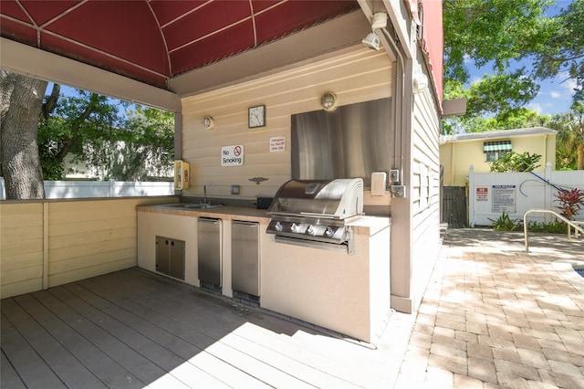 view of patio / terrace featuring a grill, sink, an outdoor kitchen, and a deck