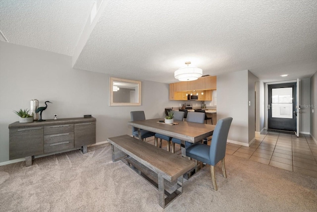 dining space featuring light colored carpet and a textured ceiling