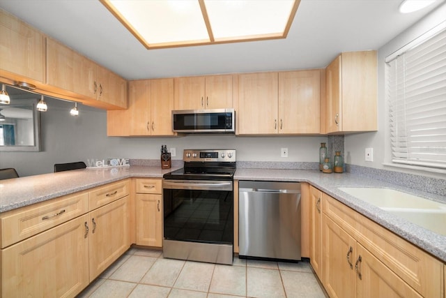 kitchen featuring light brown cabinets, stainless steel appliances, light tile patterned floors, and sink