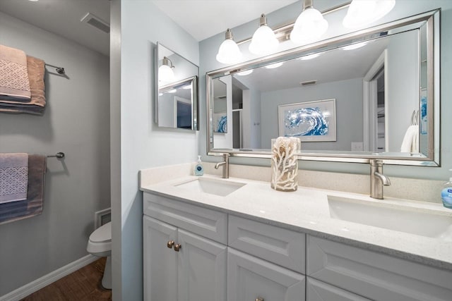 bathroom with vanity, wood-type flooring, and toilet