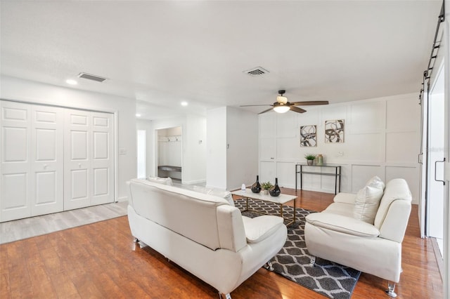 living room with wood-type flooring and ceiling fan