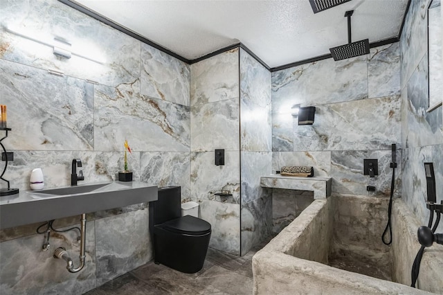 bathroom with a textured ceiling, tile walls, ornamental molding, and sink