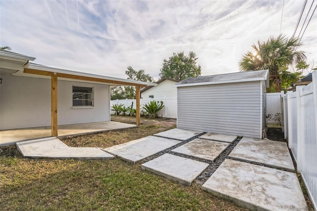 view of yard featuring a storage shed and a patio area