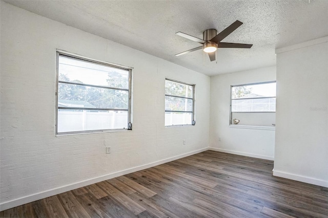 empty room featuring a ceiling fan, wood finished floors, baseboards, and a textured ceiling