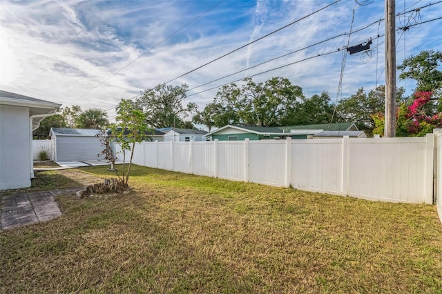 view of yard with a storage shed, an outdoor structure, and fence