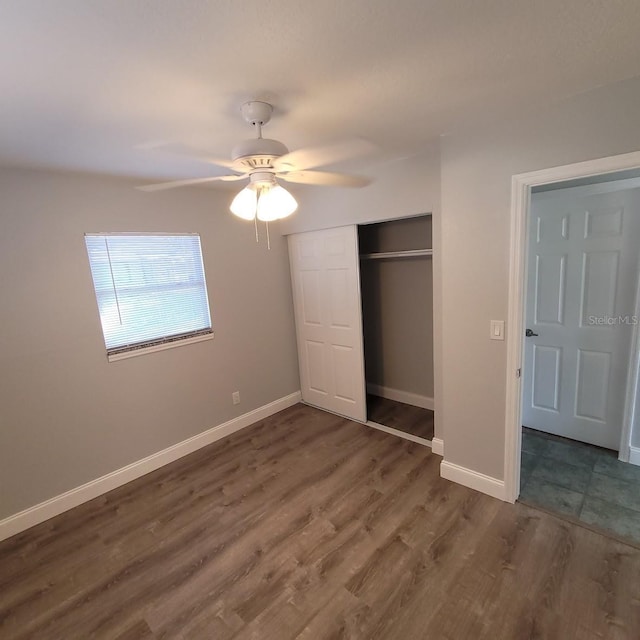 unfurnished bedroom featuring dark hardwood / wood-style flooring, a closet, and ceiling fan