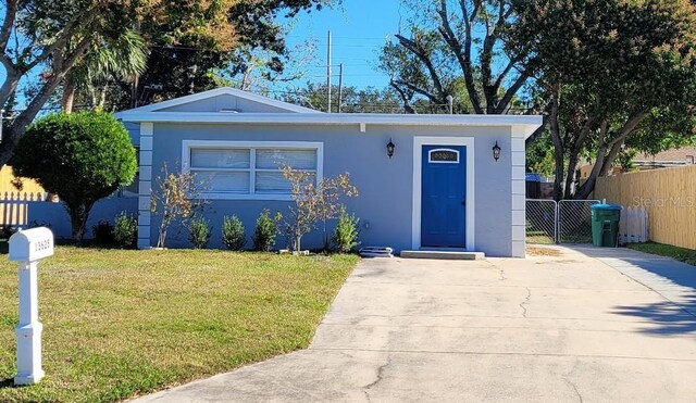 single story home with a front lawn, fence, and stucco siding