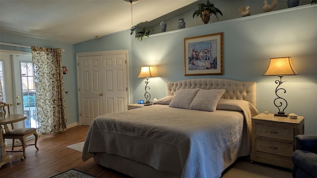 bedroom with french doors, dark hardwood / wood-style floors, vaulted ceiling, and a closet