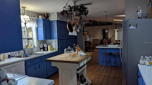 kitchen featuring stainless steel fridge, a center island, blue cabinets, and sink