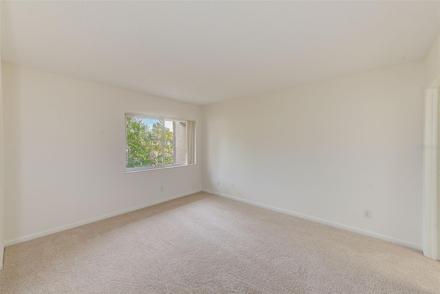 unfurnished room featuring light colored carpet