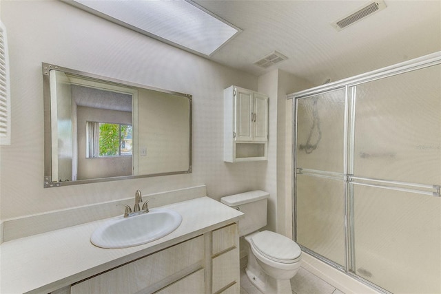 bathroom featuring vanity, an enclosed shower, and toilet