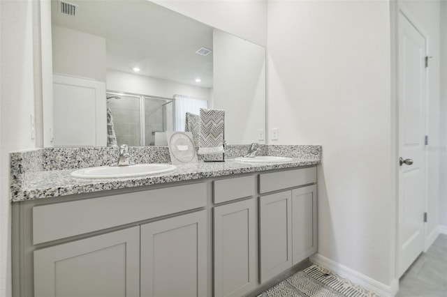 bathroom with tile patterned flooring, vanity, and a shower with door