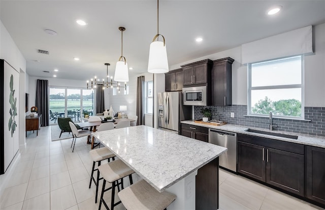 kitchen featuring decorative light fixtures, stainless steel appliances, a wealth of natural light, and sink