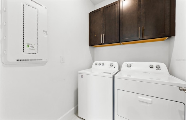 washroom with washer and dryer and cabinets