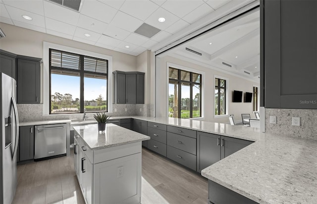 kitchen featuring light stone counters, gray cabinetry, visible vents, and stainless steel appliances