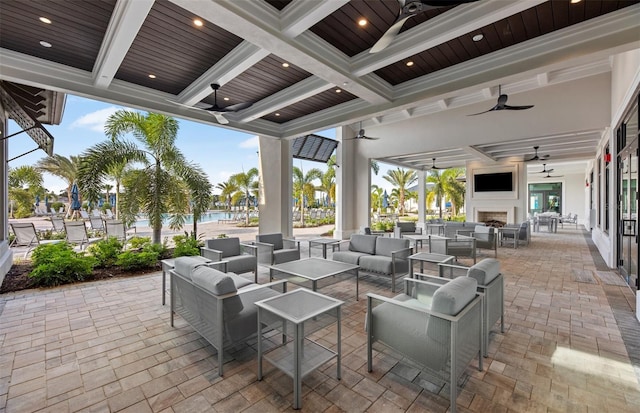 view of patio with an outdoor living space with a fireplace and ceiling fan