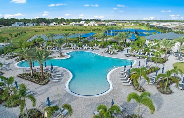 pool featuring a patio area, a water view, and a residential view