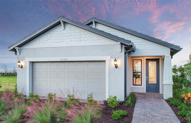 ranch-style house featuring a garage and stucco siding