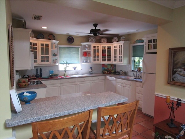 kitchen with tasteful backsplash, white cabinetry, and white appliances