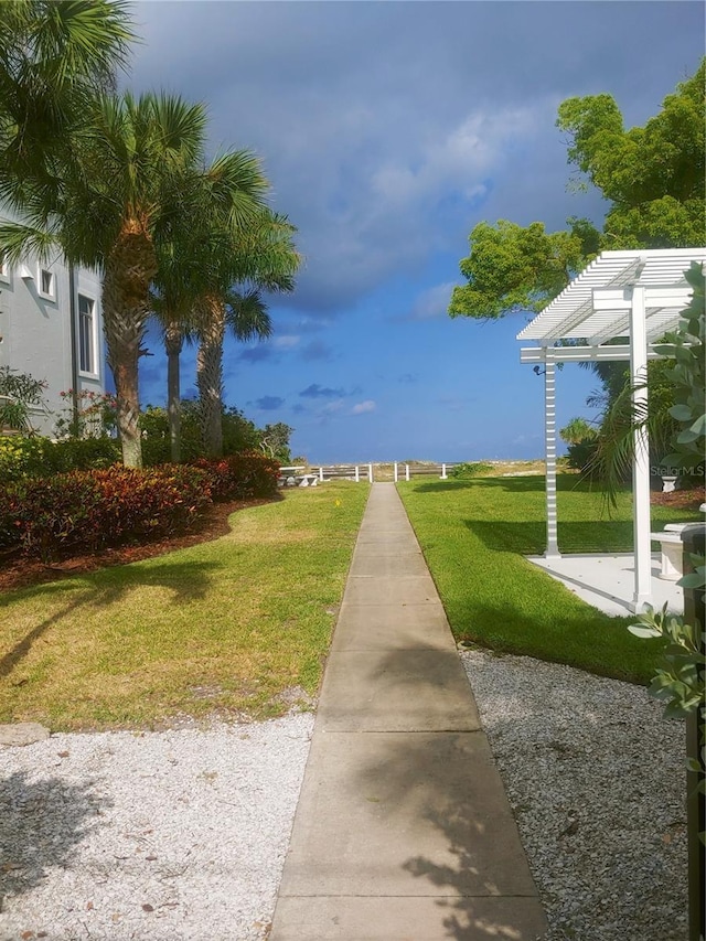 view of home's community featuring a pergola and a lawn