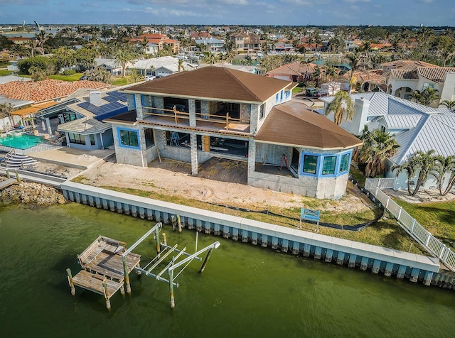 rear view of house with a balcony and a water view