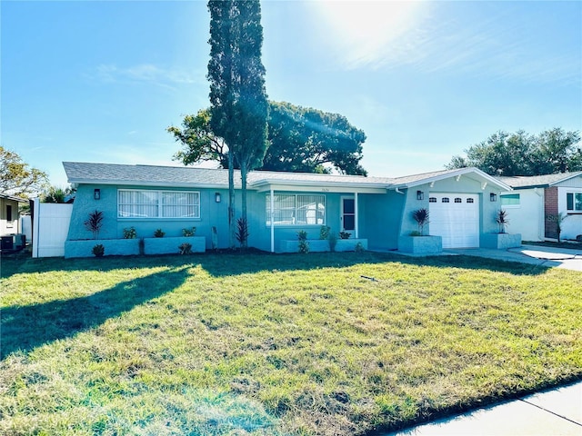 ranch-style home featuring central AC, a front lawn, and a garage