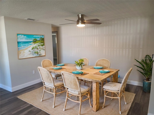 dining space with a textured ceiling, dark hardwood / wood-style flooring, and ceiling fan